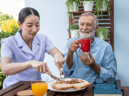 Caregiver Giving Food to an Elderly Man